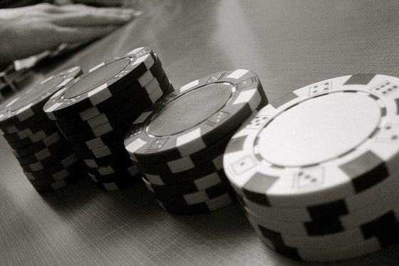 Cuatro torres de fichas de poker de altura decreciente sobre una mesa
