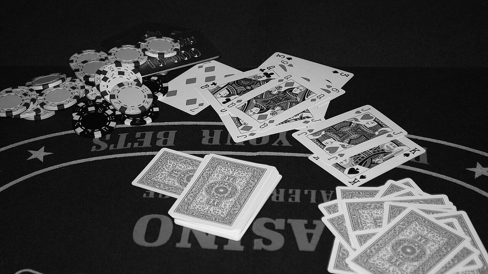 Cartas y fichas repartidas sobre una mesa de poker de casino