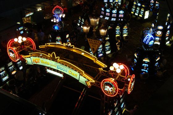 Carteles de neón de máquinas tragamonedas dentro de un casino de noche