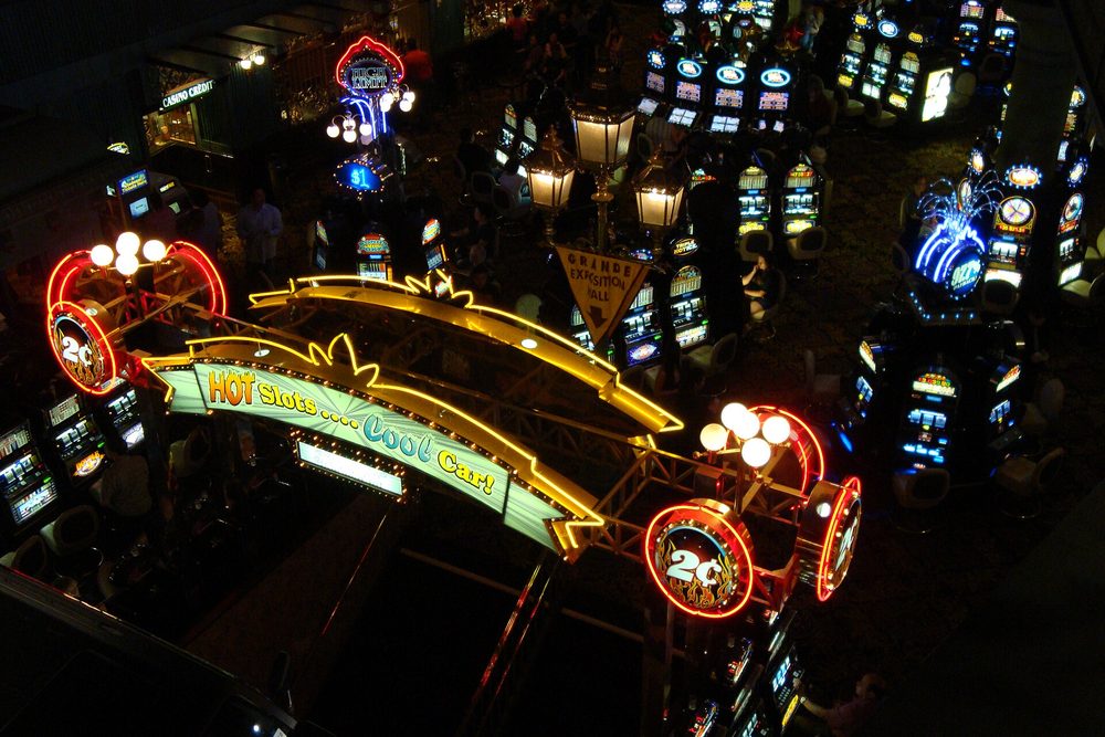 Carteles de neón de máquinas tragamonedas dentro de un casino de noche
