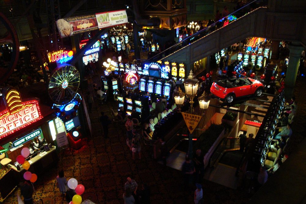 Rows of illuminated gaming machines along a casino floor