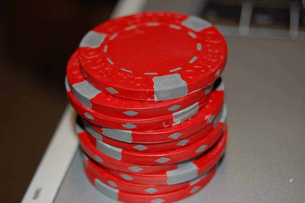Una torre alta de fichas de poker rojas con poca profundidad de campo