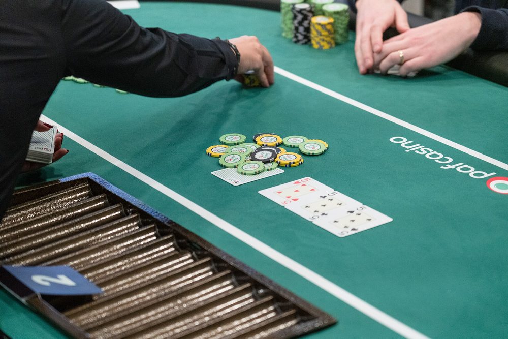 Un crupier repartiendo cartas sobre el tapete verde de una mesa final en vivo