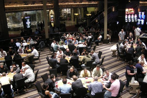 Decenas de mesas de poker ocupadas llenando la sala de cartas de un casino