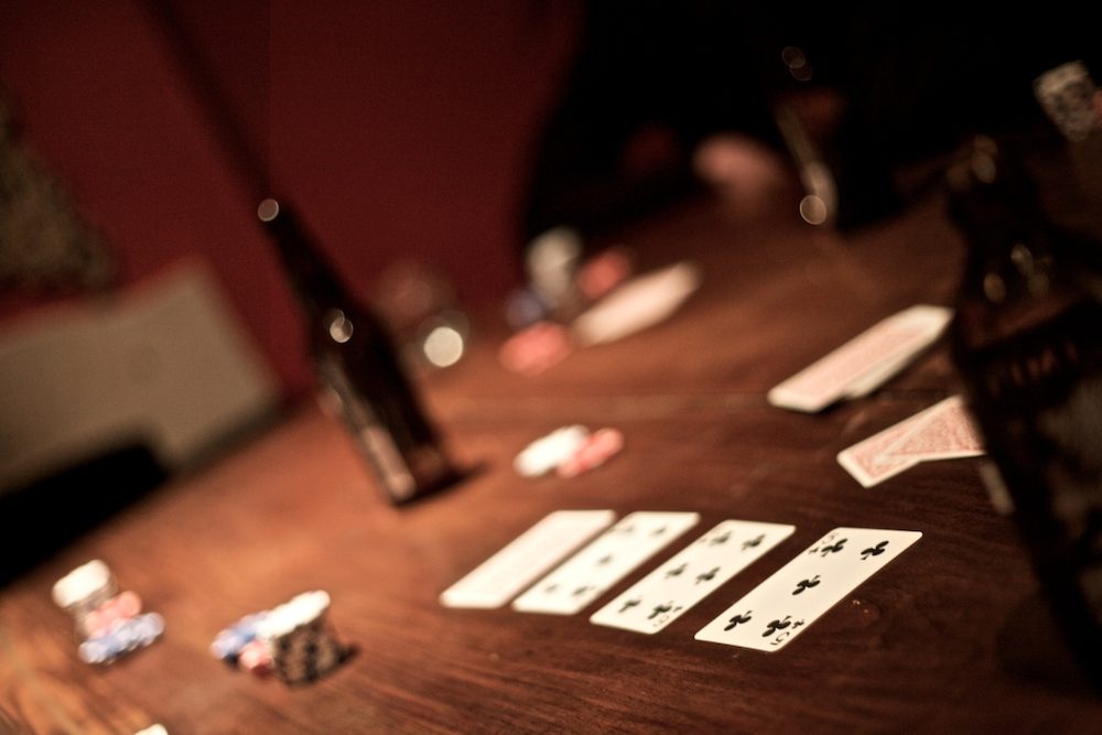 Cartas repartidas sobre una mesa de poker privada con poca luz