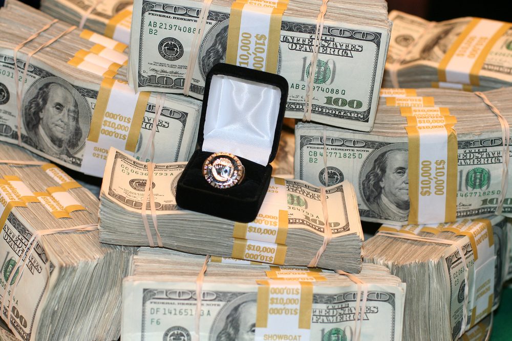 Un anillo de campeón en su estuche abierto sobre fajos de billetes